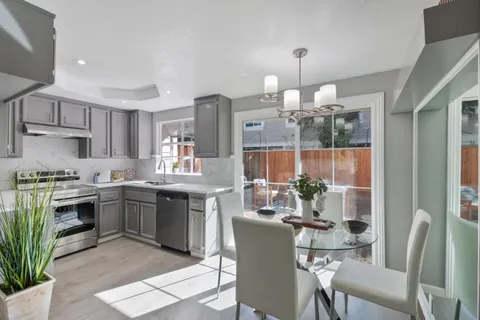 a kitchen with kitchen island granite countertop a sink cabinets and stainless steel appliances