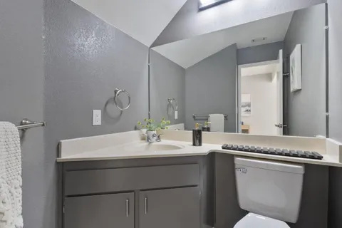 a bathroom with a granite countertop sink and a mirror