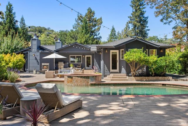 a patio with sofas fire pit table and chairs