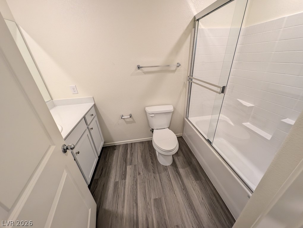 4820 Orchid Rdg Avenue Las Vegas, NV 89141 - Photo 24 of 27 Modern bath with clean lines features a single vanity, a toilet, and a glass-enclosed shower-tub combination.