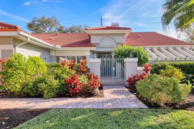 a view of a house with a yard and potted plants