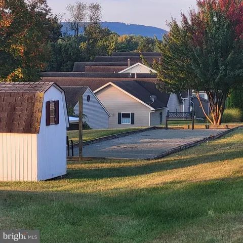 a front view of house with yard and mountain view in back