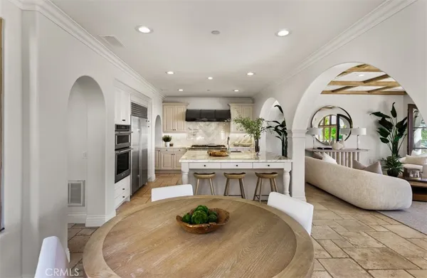 a kitchen that has a lot of white cabinets and couches in it