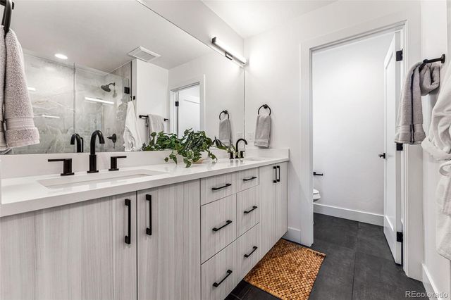a bath room with double vanity sink and mirror