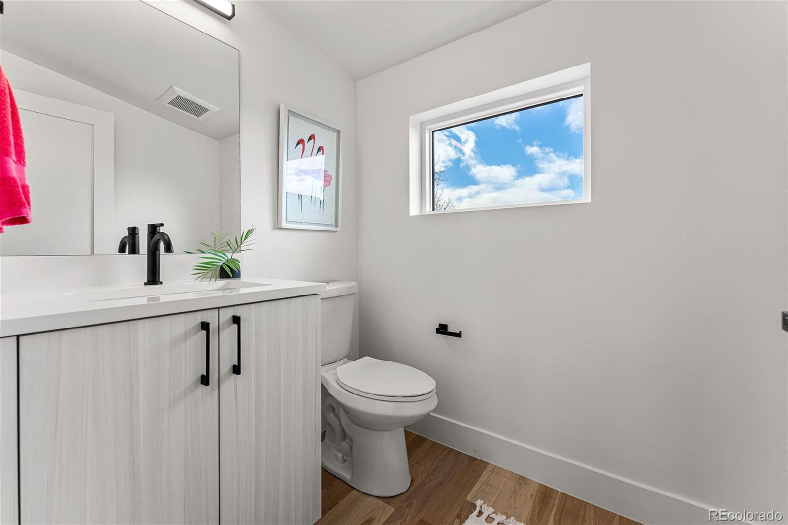 2410 South Bannock Street Denver, CO 80223 - Photo 31 of 40 a bathroom with a toilet sink and mirror