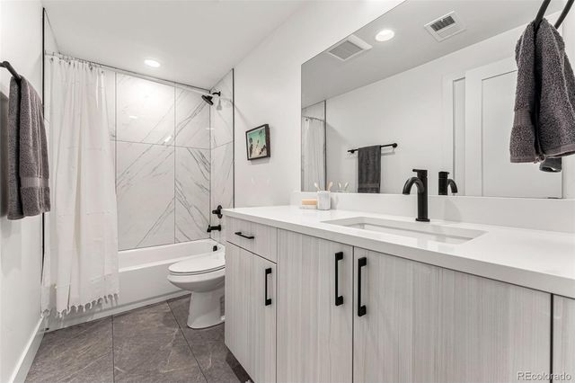 a bathroom with a double vanity sink toilet mirror and bathtub