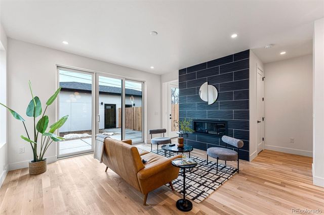 a living room with furniture a fireplace and a potted plant