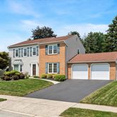 a front view of a house with a yard and potted plants