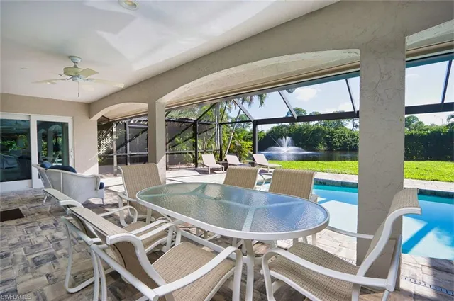 a dining room with furniture a chandelier and a floor to ceiling window