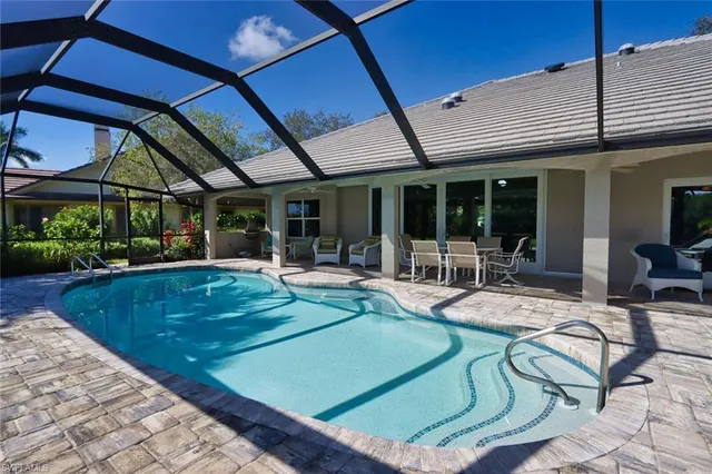 a view of a backyard with swimming pool and sitting area