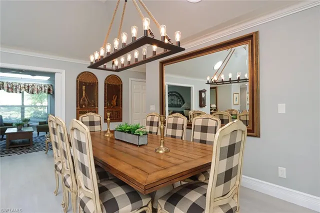 a view of a dining room with furniture a chandelier and large windows