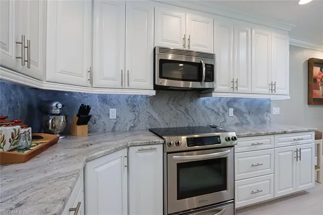 a kitchen with white cabinets and appliances