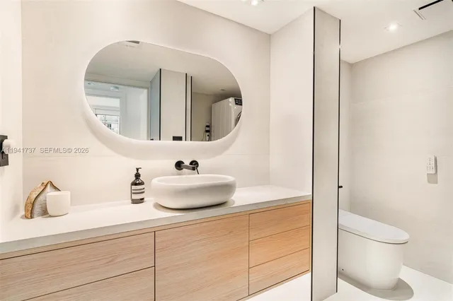 a bathroom with a toilet sink and mirror