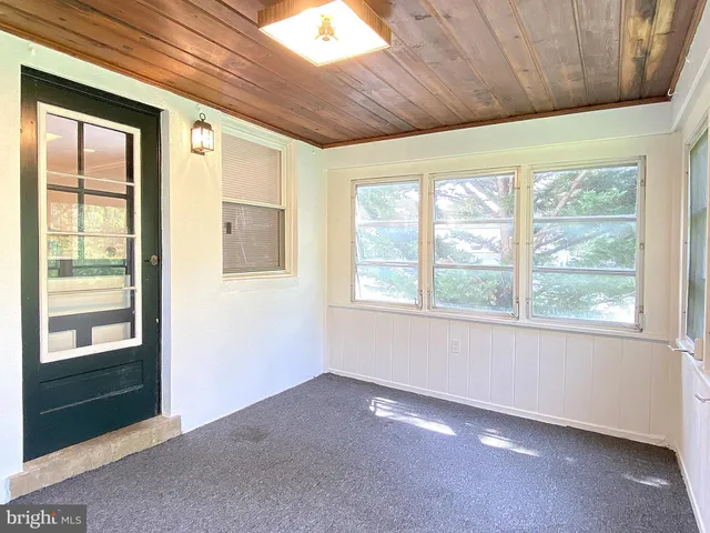 a bathroom with a shower and a sink mirror next to a window