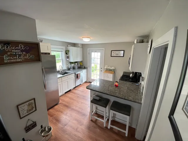 a kitchen with a table chairs refrigerator and microwave