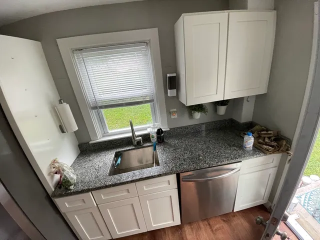 a kitchen with granite countertop a sink a granite counter tops and a wooden floor