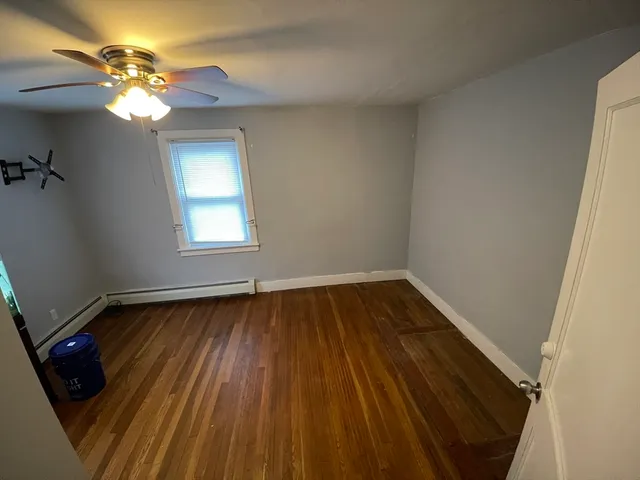 en empty room with wooden floor fan and window