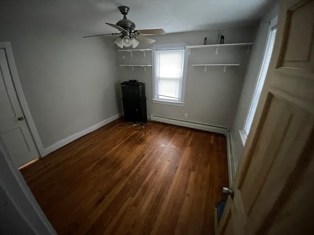 a view of a room with wooden floor and a bathroom