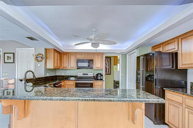 a kitchen with granite countertop a sink a counter top space and stainless steel appliances