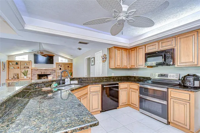 a large kitchen with stainless steel appliances granite countertop a stove granite counter tops and white cabinets