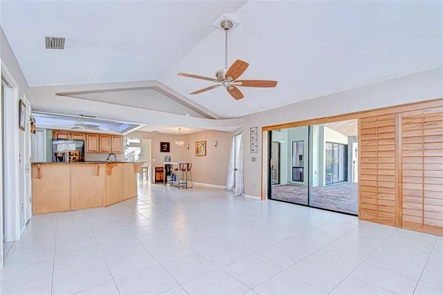 a view of an empty room with a window and a kitchen