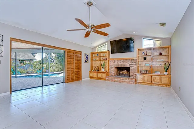a view of an empty room with a fireplace and a window