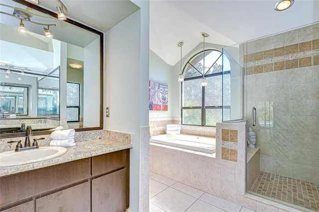 a bathroom with a granite countertop tub sink and mirror
