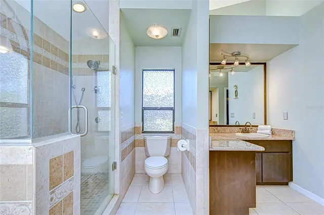 a bathroom with a granite countertop sink toilet and shower