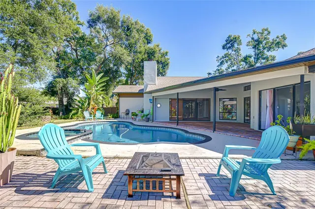 a view of house with swimming pool outdoor seating