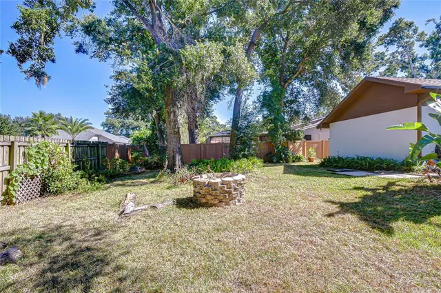 a backyard of a house with a garden and outdoor seating