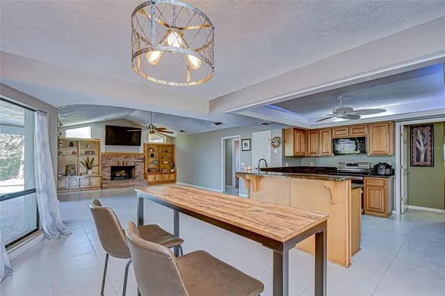 a kitchen with stainless steel appliances granite countertop a stove top oven a sink dishwasher a dining table and chairs with wooden floor