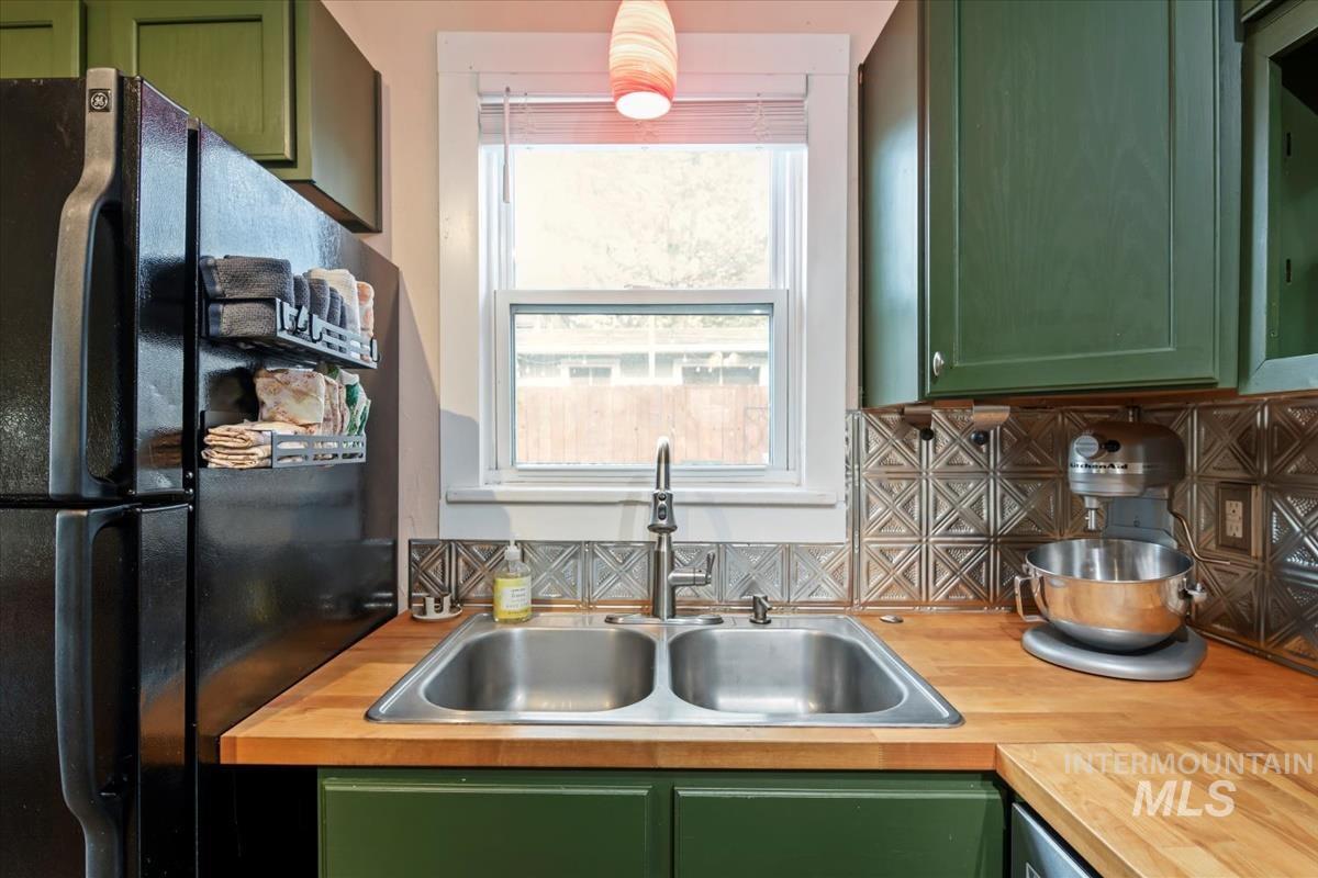 2837 Ona Street Boise, ID 83705 - Photo 16 of 26 Kitchen with green cabinets, freestanding refrigerator, backsplash, and light countertops