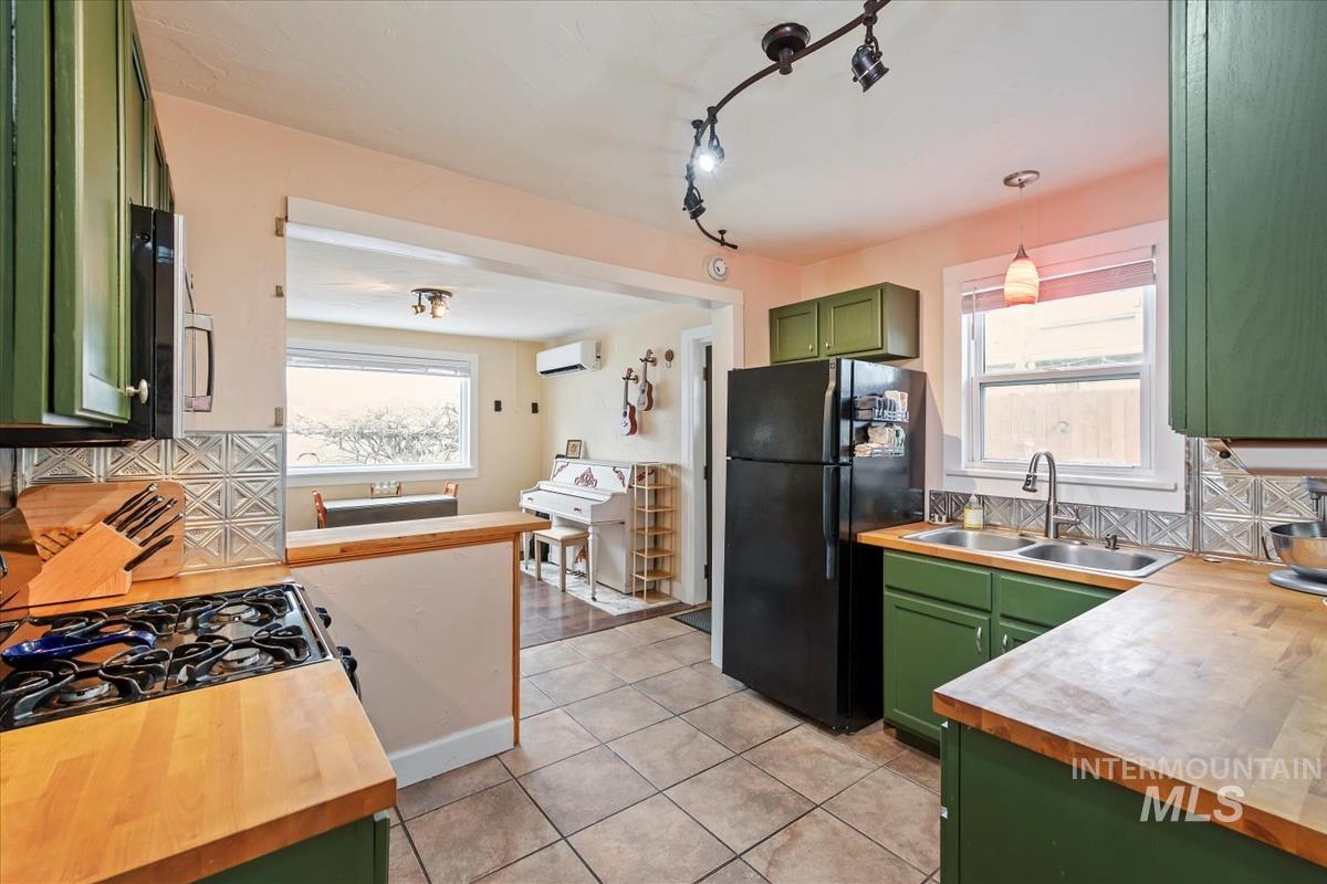 2837 Ona Street Boise, ID 83705 - Photo 18 of 26 Kitchen featuring green cabinets, backsplash, freestanding refrigerator, butcher block counters, and hanging light fixtures