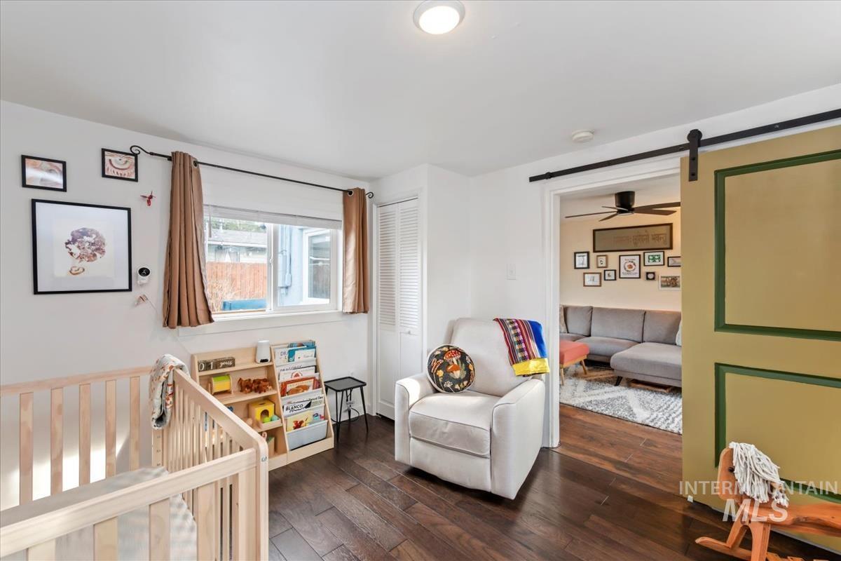 2837 Ona Street Boise, ID 83705 - Photo 24 of 26 Bedroom featuring a barn door, dark wood finished floors, a nursery area, and a closet