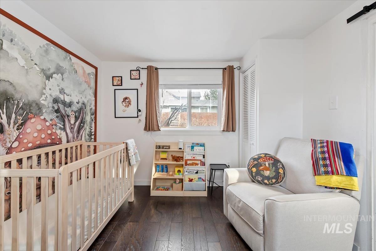 2837 Ona Street Boise, ID 83705 - Photo 25 of 26 Bedroom featuring a crib, dark wood finished floors, a closet, and a barn door