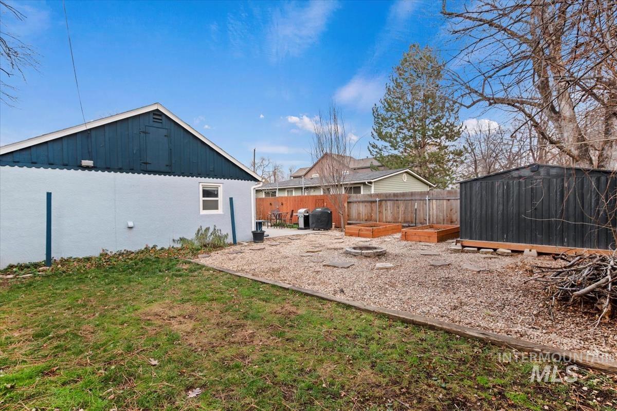 2837 Ona Street Boise, ID 83705 - Photo 7 of 26 Fenced backyard with a vegetable garden, a patio area, and a storage shed