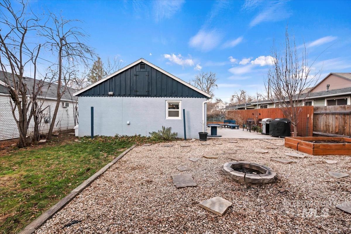 2837 Ona Street Boise, ID 83705 - Photo 8 of 26 View of property exterior with a vegetable garden, a fire pit, board and batten siding, and a patio
