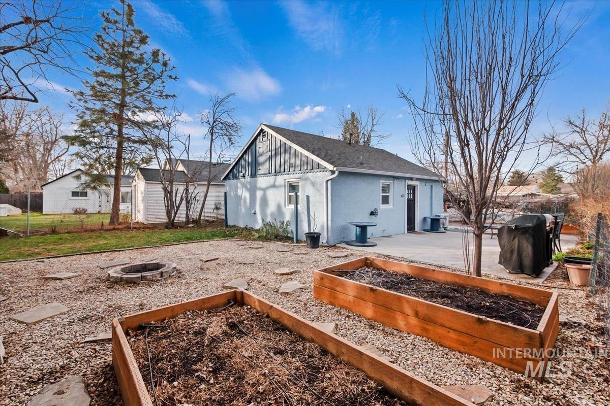2837 Ona Street Boise, ID 83705 - Photo 9 of 26 Rear view of house with a patio area, board and batten siding, a fire pit, and a garden