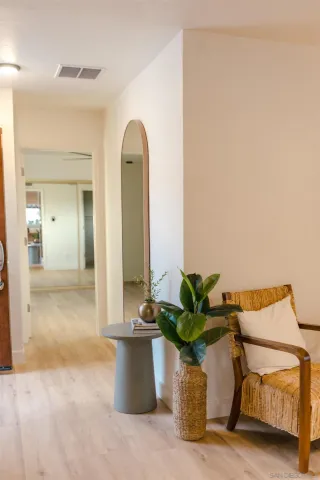 a dining room with wooden floor a chandelier a wooden table and chairs