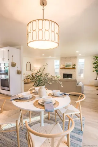 a kitchen with refrigerator a stove a sink and chairs