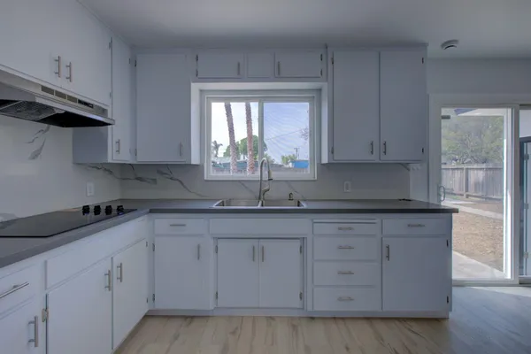 a kitchen with granite countertop white cabinets and a sink