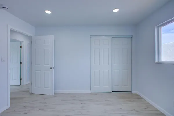 an empty room with windows and closet area