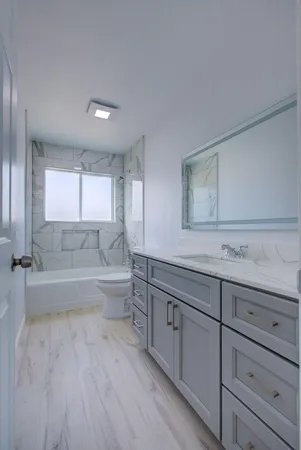 a spacious bathroom with a tub sink and view living room