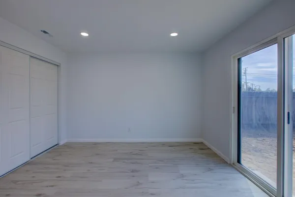 a view of a room with wooden floor and window