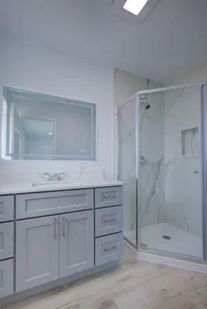 a bathroom with a shower sink and mirror