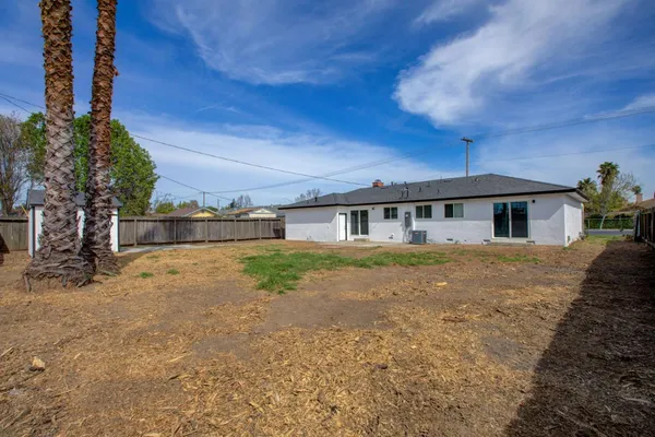 a front view of a house with a yard and trees
