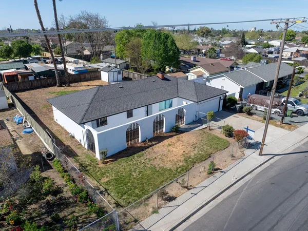 an aerial view of a house with a garden and lake view