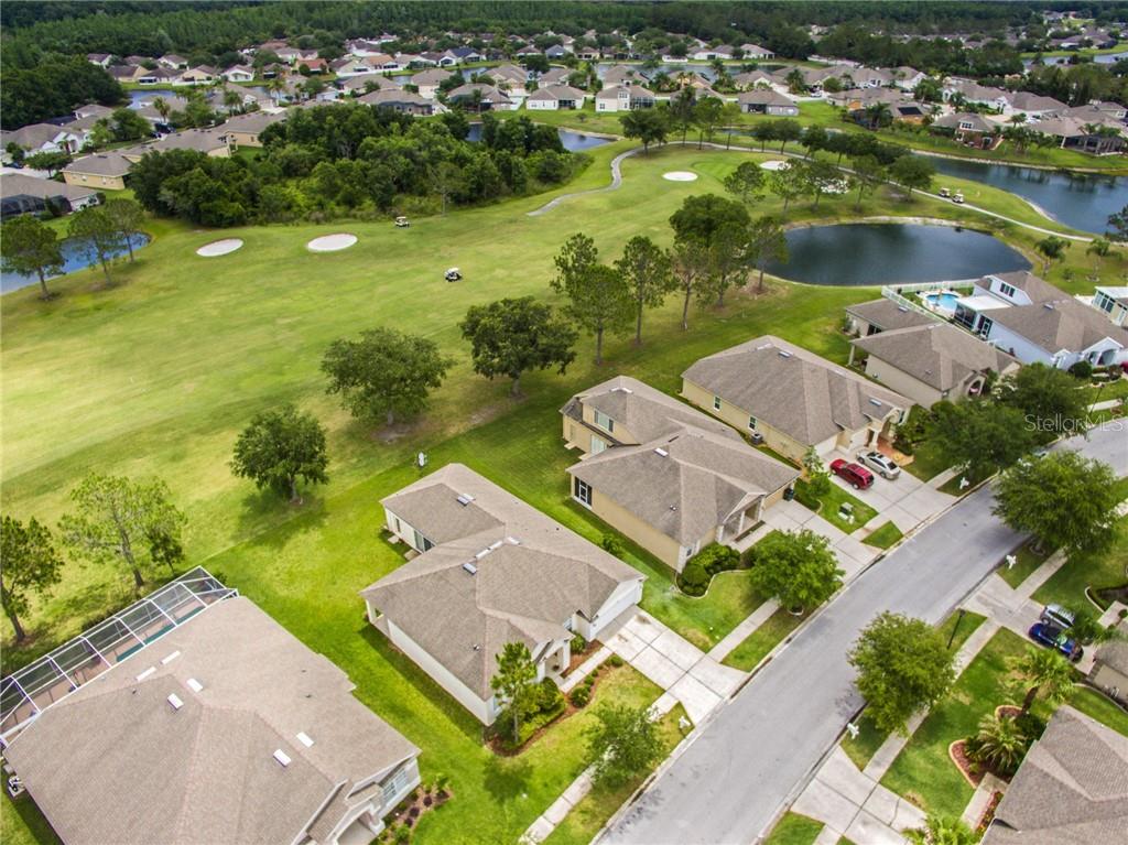 an aerial view of residential houses with outdoor space and lake view