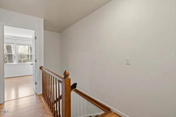 a view of a hallway with wooden floor and stairs