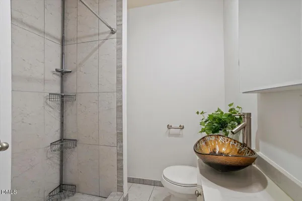 a bathroom with a toilet and a potted plant